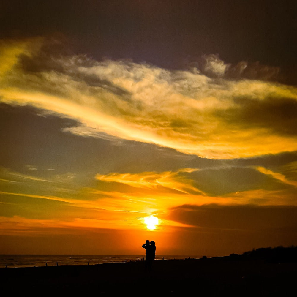 billede af to personer der holder om hinanden ved solnedgang