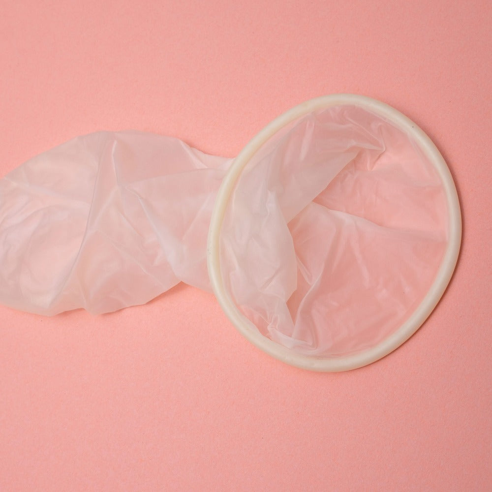 kondom på lyserød baggrund