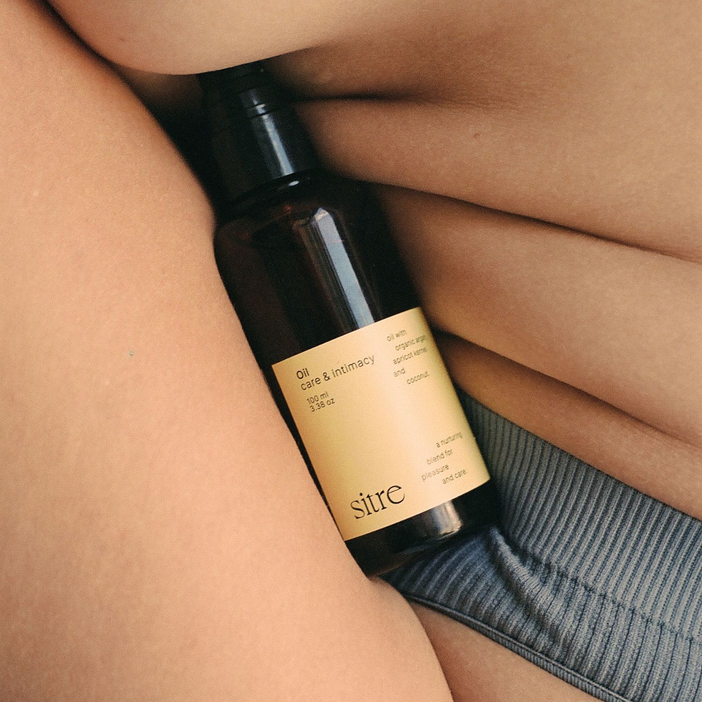 Sitre care and intimacy oil glidecreme liggende på krop